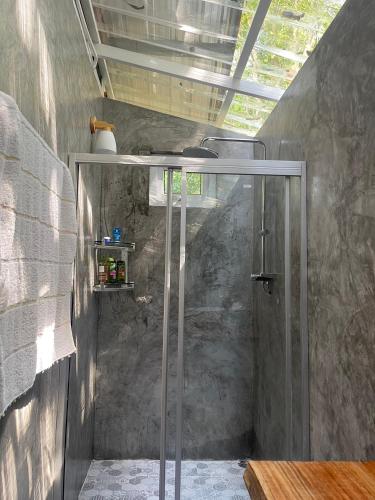 a shower with a glass door in a bathroom at Big hug home-Forest House in Ban Takhrai