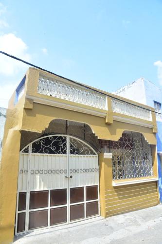un edificio amarillo con balcón en la parte superior en S & H Stay Home, en Mysore