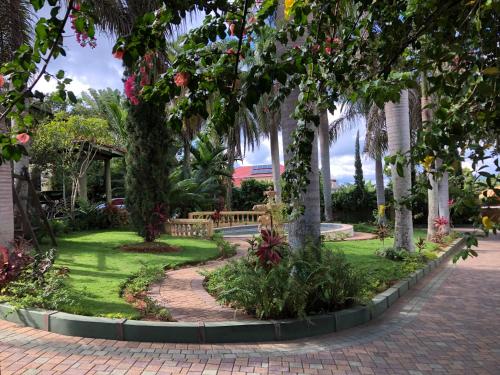 a garden with trees and a brick walkway at Hidden oasis in Mandeville