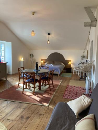 uma sala de estar com uma mesa e cadeiras e uma cama em Maison Graciateguy em Saint-Étienne-de-Baïgorry