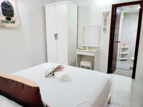 a white room with a bed with a mirror at Amore Apartment, Maldives in Dhangethi