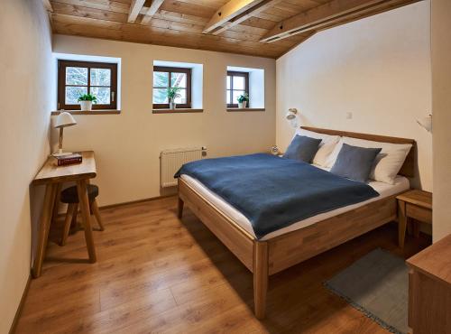 1 Schlafzimmer mit einem Bett, einem Schreibtisch und 2 Fenstern in der Unterkunft Na jelení stezce in Chřibská