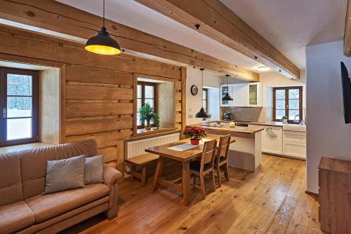 eine Küche und ein Wohnzimmer mit einem Sofa und einem Tisch in der Unterkunft Na jelení stezce in Chřibská
