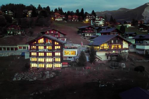 a lit up building in a village at night at Hotel Bellwald in Bellwald