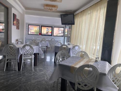a dining room with tables and chairs and a television at Hotel Rudo in Predeal