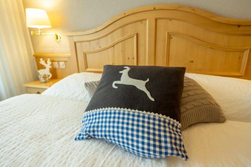 a pillow with a dog on it sitting on a bed at Hotel Bellwald in Bellwald