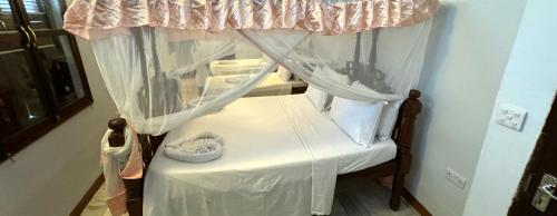 a small bed with a canopy in a room at Princess Salme Inn in Zanzibar City
