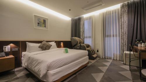 a bedroom with a bed and a desk and a chair at Pangyo Business & Tourist Hotel KYND in Seongnam