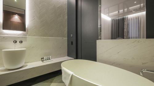Kynd Hotel في سيونغنام: حمام مع حوض أبيض ومغسلة