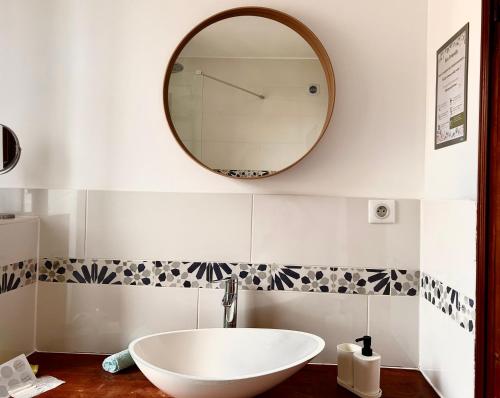 baño con lavabo y espejo en la pared en Chez Myriam en Orgeval