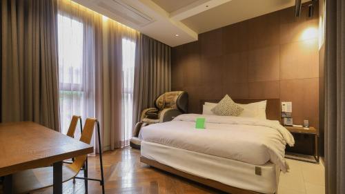 Kynd Hotel في سيونغنام: غرفة نوم بسرير وطاولة ومكتب