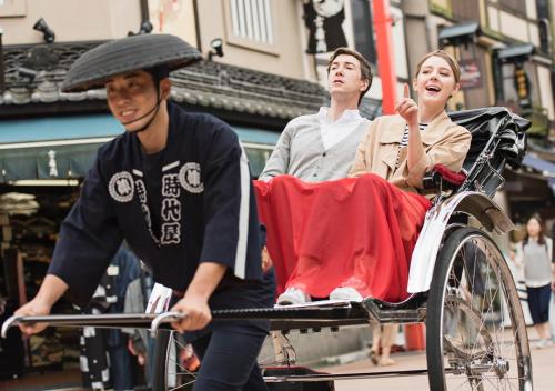 a man pushing a woman in a cart at APA Hotel Asakusa Kaminarimon Minami in Tokyo