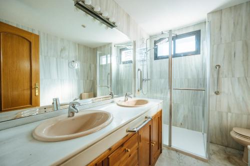 ein Bad mit 2 Waschbecken und einer Dusche in der Unterkunft acogedor piso con parking santa justa in Sevilla