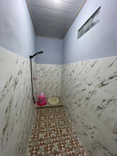uma casa de banho com um chuveiro e piso em azulejo em Villa Cakrawala em Tawangmangu