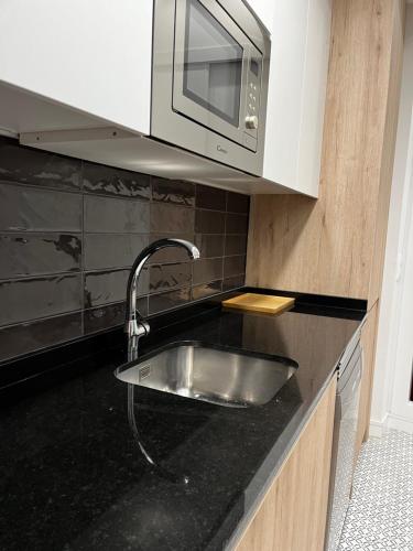 a kitchen with a sink and a microwave at Exyca Méndez Álvaro in Madrid