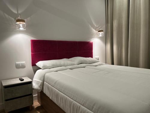 um quarto com uma cama grande e uma cabeceira vermelha em Exyca Méndez Álvaro em Madri