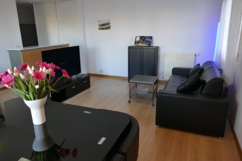 a living room with a couch and a vase of flowers at Disneyland Paris 70m² face Parc, place Ariane in Serris
