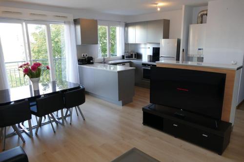 a kitchen with a table and some chairs in it at Disneyland Paris 70m² face Parc, place Ariane in Serris