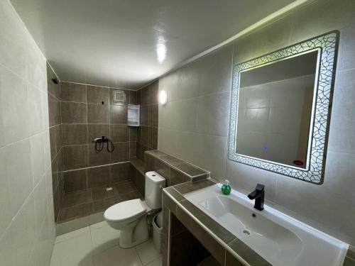 y baño con aseo, lavabo y espejo. en Riad Dar Naima Imsouane, en Imsouane