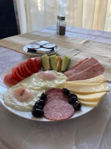 un plato de alimentos para el desayuno en una mesa en Hotel Rudo, en Predeal