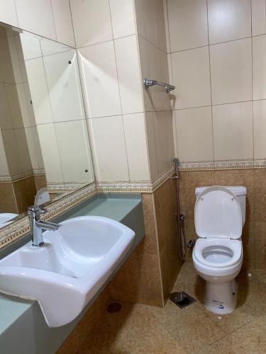 a bathroom with a sink and a toilet and a mirror at Jovian guest house in Dubai