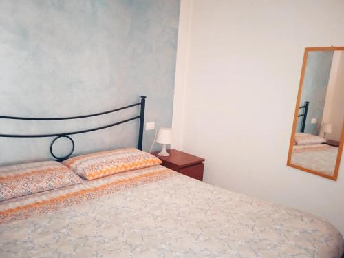 sypialnia z łóżkiem i lustrem w obiekcie Casa Amalia w mieście Boario Terme