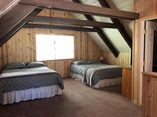 two beds in a attic room with a window at Pops Place in Arnold