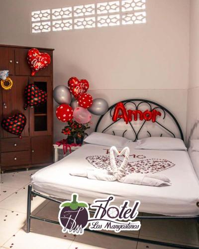 um quarto com uma cama com corações e balões em Hotel los Mangostinos calle 7 número 5-26 frente al expreso Bolivariano em Mariquita