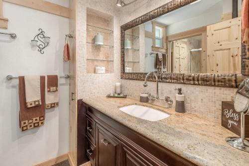 a bathroom with a sink and a mirror at Cozy Bear Cabin in Arnold