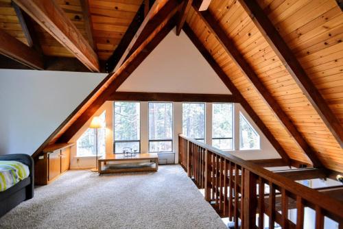 a attic room with wooden ceilings and a large window at Dancing With Trees in Arnold