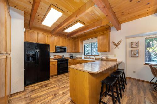 a kitchen with wooden cabinets and a black refrigerator at Evergreen Lodge in Arnold