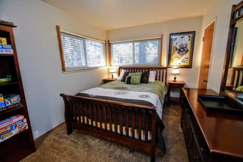 a bedroom with a bed and a desk and two windows at Casa Cazadores in Arnold