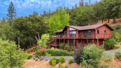 a red house on a hill with trees at Murphys View in Murphys