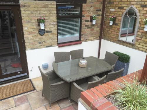 a table and chairs on the patio of a house at Harpenden House in Harpenden