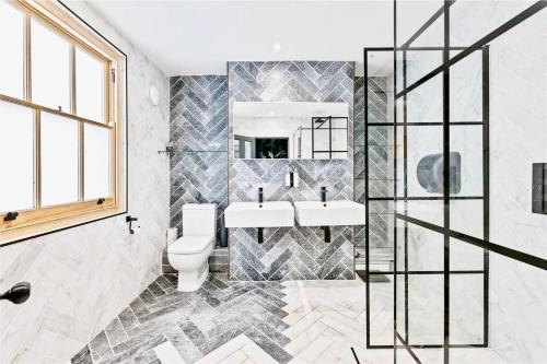 ein Badezimmer mit zwei Waschbecken und einem WC in der Unterkunft Stylish, Central, North Laine, Newly Decorated in Brighton & Hove