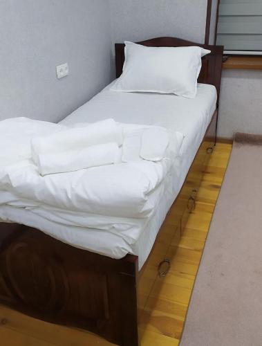 タシュケントにあるГостевой дом Мусоのベッド(白いシーツ、枕付)