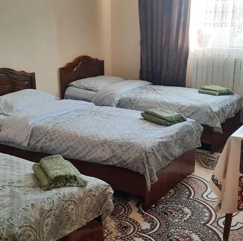 a room with three beds and a window at Гостевой дом Мусо in Tashkent