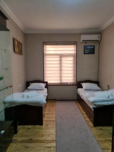 タシュケントにあるГостевой дом Мусоのベッドルーム1室(ベッド2台、ブラインド付きの窓付)が備わります。