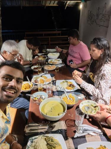 a group of people sitting around a table eating food at White Villa Kitulgala in Kitulgala