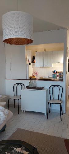 - une cuisine avec 2 chaises et une table dans l'établissement La goélette, à Saint-Cyprien