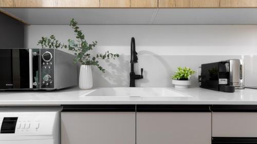 a kitchen counter with a sink and a microwave at אורה דירות אירוח - 6008 - דירות חדר שינה וסלון במרחק הליכה מהים in Eilat