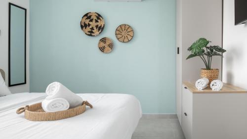 a bedroom with a bed with towels and clocks on the wall at אורה דירות אירוח - 6008 - דירות חדר שינה וסלון במרחק הליכה מהים in Eilat