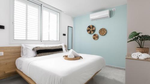 a white bedroom with a large bed and a window at אורה דירות אירוח - 6008 - דירות חדר שינה וסלון במרחק הליכה מהים in Eilat
