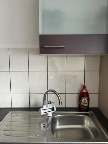 un fregadero con una botella de detergente de limpieza al lado en AK Ferien-Monteurwohnung en Olpe