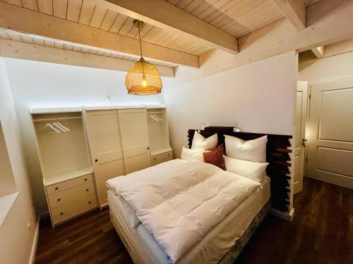 a bedroom with a bed with white sheets and pillows at Muggelhuus das Ferienhaus im Alten Land / Pflaumenbaum in Twielenfleth