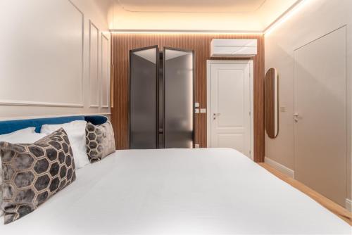 a bedroom with a large white bed and a closet at Maison Ginori Guelfa in Florence