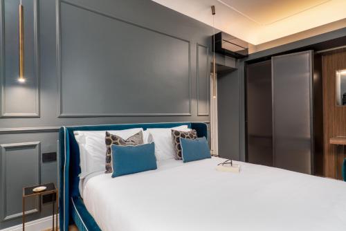 a bedroom with a large white bed with blue accents at Maison Ginori Guelfa in Florence