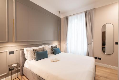 a bedroom with a large white bed and a window at Maison Ginori Guelfa in Florence