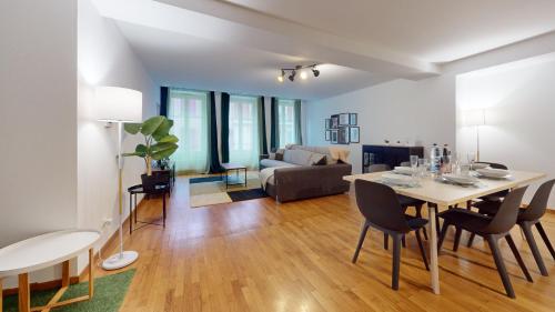 une salle à manger et un salon avec une table et des chaises dans l'établissement ColmarAppart Vauban, à Colmar