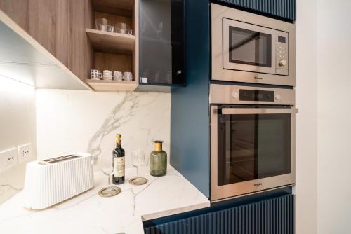 a kitchen with a microwave and wine bottles on a counter at Maison Ginori Guelfa in Florence